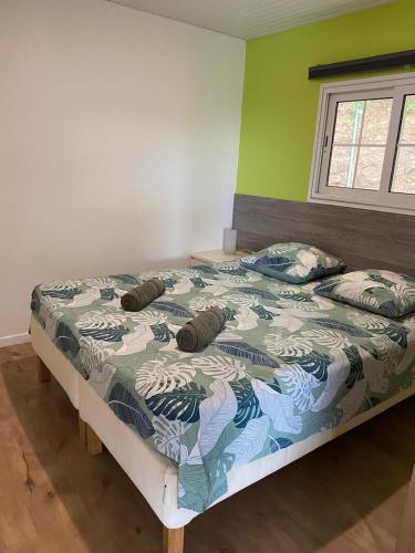 a bed with two pillows on it in a bedroom at Le domaine de Périolat in Le François