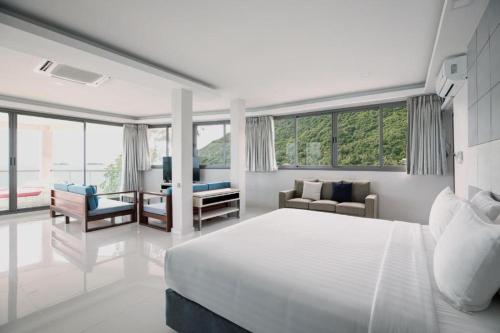 a white bedroom with a bed and a living room at Oh La La Koh Phangan in Haad Rin
