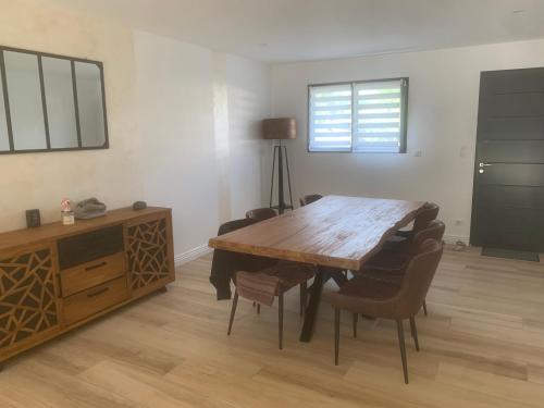 une salle à manger avec une table et des chaises en bois dans l'établissement Maison de plein pied à Arnage proche du circuit, à Arnage