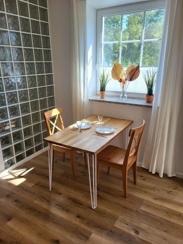 a dining room table with two chairs and a window at 2-Zimmer Wohnung 2 - Apartments am Schloss in Oberschleißheim