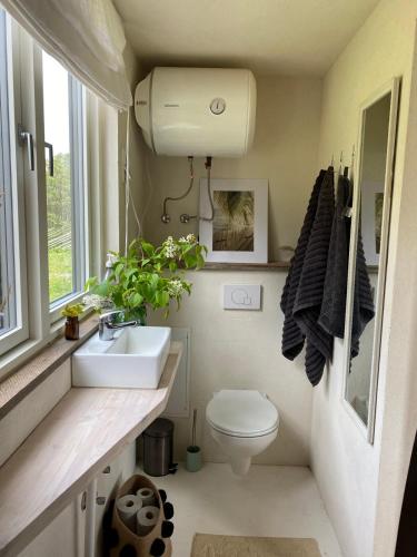 a bathroom with a toilet and a sink and a window at JES Kalana Beachhouse in Kalana