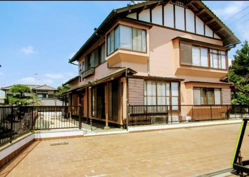 a large house with a fence in front of it at Ryokan Gallery Tokyo in Kamagaya