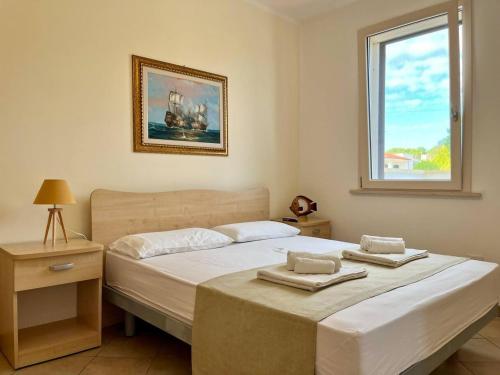 een slaapkamer met een bed met twee handdoeken erop bij Yellow Beachfront house 60 m by Salento Prime in Marina di Pescoluse