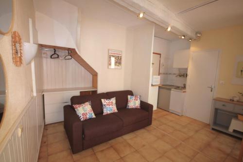 un salon avec un canapé marron et une cuisine dans l'établissement Treille 1 1er étage, à Collioure