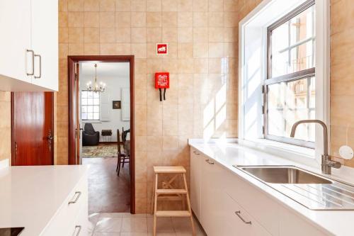 una cucina con un lavandino e una finestra di Casa da Avó Zilda a Guimarães