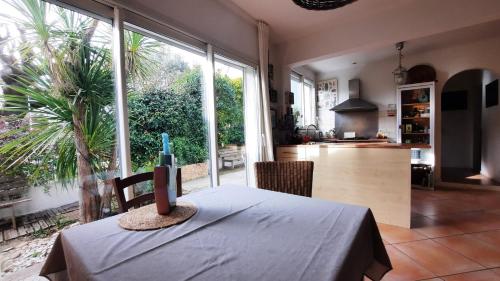 une salle à manger avec une table et une cuisine dans l'établissement Maison centre Montpellier Jardin et proche plage, à Montpellier