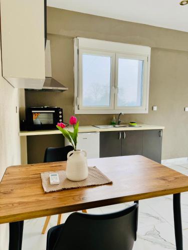 a kitchen with a wooden table with a vase with a flower at Villa Athina 1 in Serres