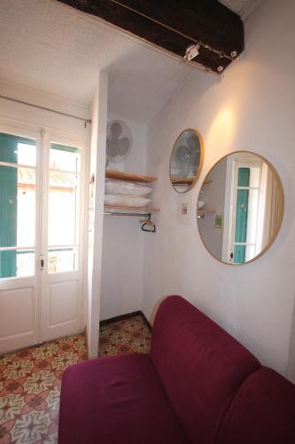 un salon avec un canapé rouge et un miroir dans l'établissement Treille 2 2ème étage, à Collioure