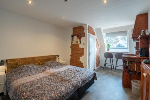 a bedroom with a bed and a brick wall at Appartementen De Witte Brugh in Buren