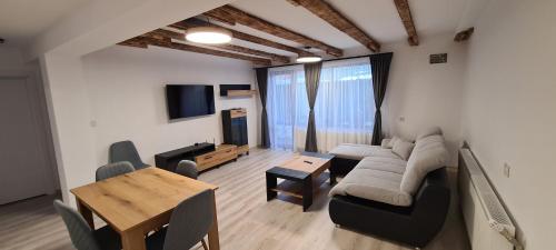 a living room with a couch and a table at Къща за гости Сънрайс Чепеларе in Chepelare