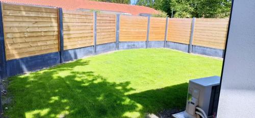 a yard with a fence and a green lawn at Bleu cargo in Biscarrosse