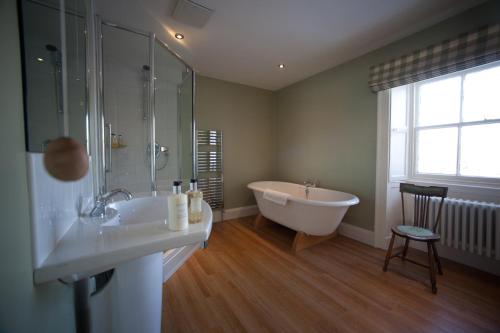 a bathroom with a tub and a sink and a shower at Newforge House in Moira