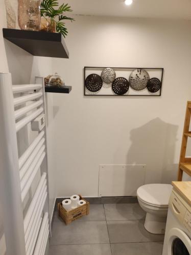 a bathroom with a toilet and plates on the wall at studio terrace swimming pool quiet expo park in Mauguio