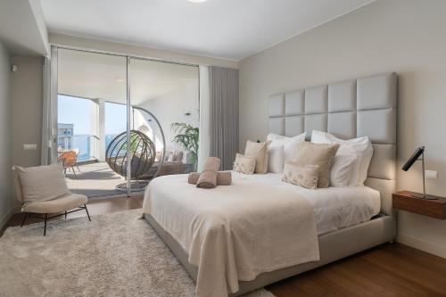 a bedroom with a large white bed and a balcony at OurMadeira - Palace Ocean View in Funchal