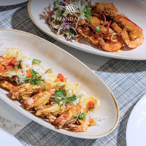 two plates of food sitting on a table at Apec MANDALA CHAM BAY MUI NE SPA RESORT AND CONDOTEL in Ấp Thiẹn Ái