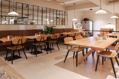 a dining room with wooden tables and chairs at Aerohotel Barcelona Airport 24h in El Prat de Llobregat