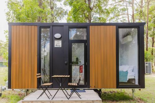 a tiny house with a black and wooden exterior at Schlaraffenland 1 by Tiny Away in Chatsworth Island