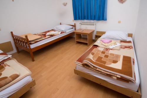 a room with two beds and a table in it at Guest House OK in Međugorje