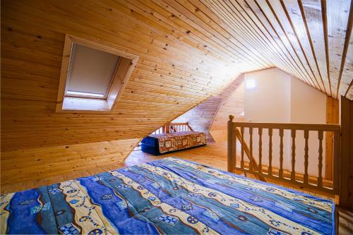 a bedroom with a large bed in a wooden room at Vineyard Cottage Maleric with Pool Access in Dragatuš
