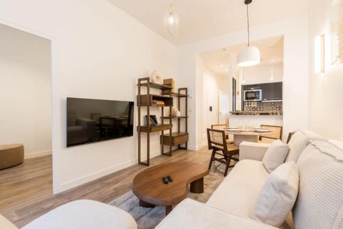 un salon avec un canapé et une table dans l'établissement Elégant appartement à deux pas du Moulin Rouge, à Paris