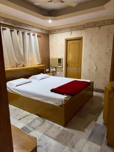 a bedroom with a bed with a red blanket on it at Shahgul's Service Apartments in Hyderabad