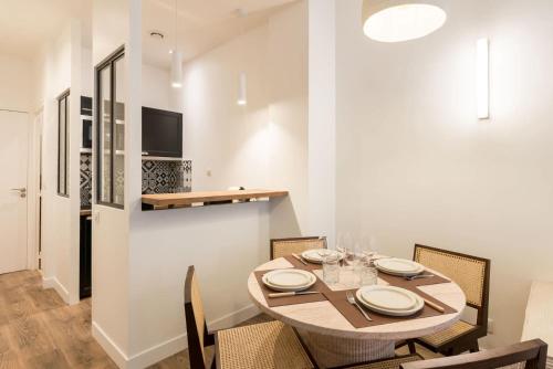 une salle à manger avec une table et des chaises dans l'établissement Elégant appartement à deux pas du Moulin Rouge, à Paris