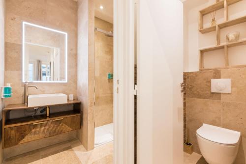 une salle de bain avec toilettes et lavabo dans l'établissement Elégant appartement à deux pas du Moulin Rouge, à Paris