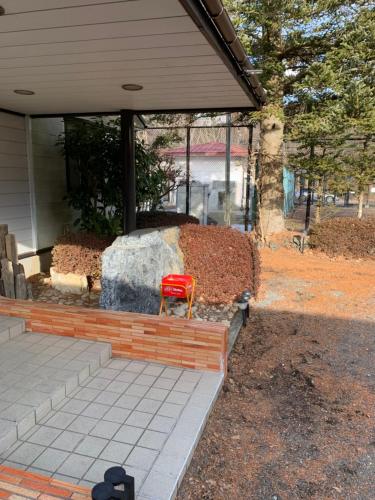 a red chair sitting in front of a house at 景雅はなれ in Yamanakako