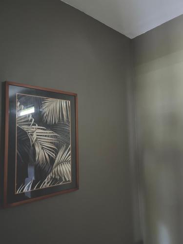 a framed picture of a palm tree on a wall at Tropical Almond Villa in Uluwatu