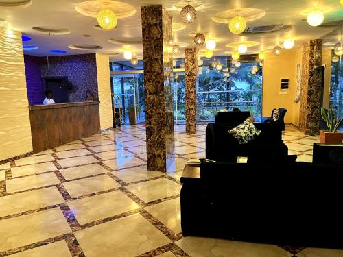 a lobby with couches and a bar in a building at Aryana Queen Beach Resort in Wadduwa