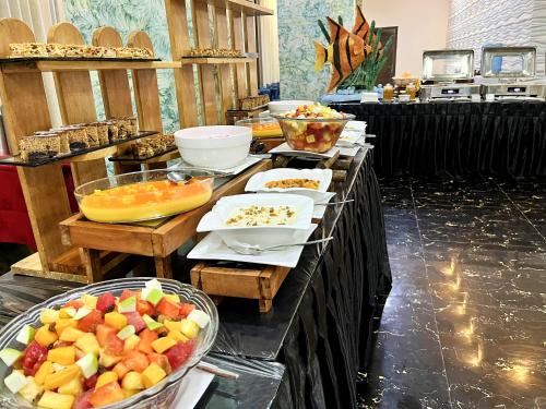 a buffet with fruits and other food on a table at Aryana Queen Beach Resort in Wadduwa
