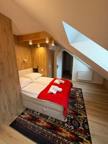 ein Schlafzimmer mit einem Bett mit einer roten Decke in der Unterkunft Apartament Delux - Przytulny Zakątek Karkonoszy in Karpacz
