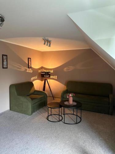 a living room with two green couches and a table at PENZION BENEŠOV u BROUMOVA in Broumov