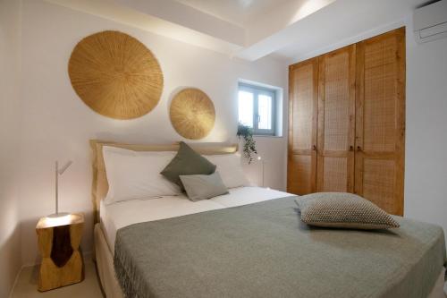 Oneiro 4BDR Villa in Antiparos Sirocco Villa في أنديباروس: غرفة نوم بسرير وباب خشبي