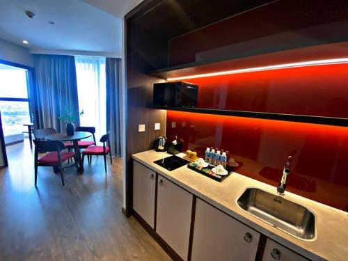 a kitchen with a sink and a table in a room at Apec MANDALA CHAM BAY MUI NE SPA RESORT AND CONDOTEL in Ấp Thiẹn Ái