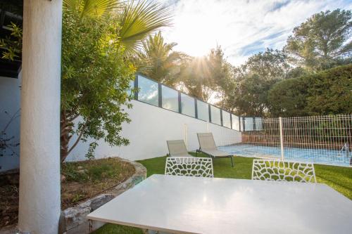 - une table et des chaises blanches dans la cour d'une maison dans l'établissement Superbe F2 Spacieux - Saint Raphael, à Saint-Raphaël