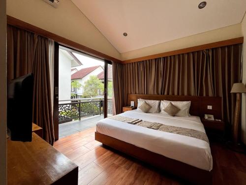 a bedroom with a large bed and a balcony at Grand Kesambi Family Villa by Miel Property in Seminyak