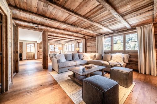 un salon avec un canapé et une table dans l'établissement Chalet Savanna, Les Gets - by EMERALD STAY, aux Gets