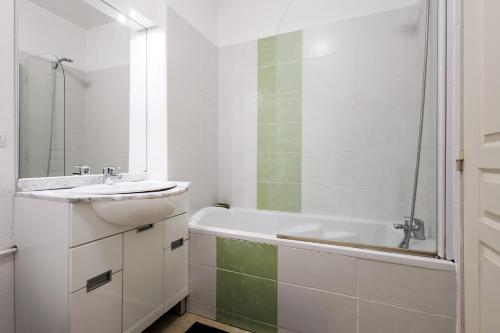 a white bathroom with a sink and a bath tub at Bastidon Provençal - Avec piscine partagée in Aubignan