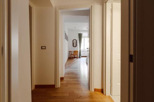 a hallway with white walls and a wooden floor at Happy Home in Rome