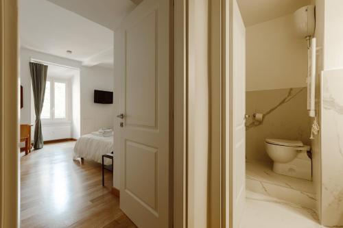 a bathroom with a toilet and a bed in a room at Happy Home in Rome