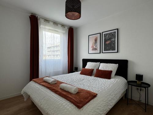 une chambre avec un lit avec deux oreillers dessus dans l'établissement casa Lyon Appartement lumineaux, à Lyon