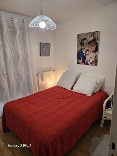 une chambre avec un lit avec une couverture rouge dans l'établissement Les terrasses du palais, à Vannes
