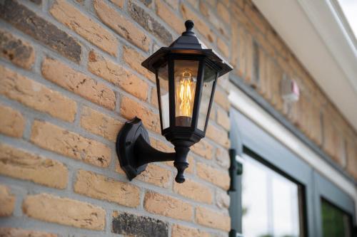 a street light attached to a brick wall at Appartementen De Witte Brugh in Buren