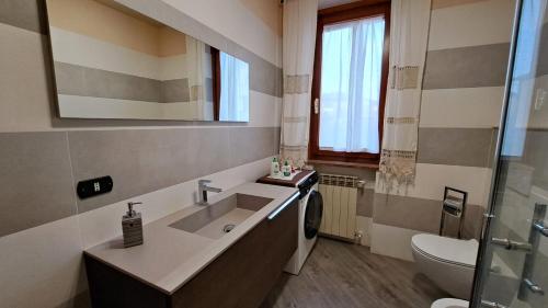 a bathroom with a sink and a toilet and a mirror at Casa Stella - Montepulciano in Montepulciano