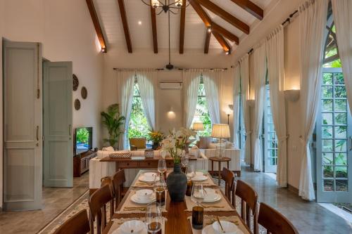 a dining room with a long table and chairs at Villa Lluvia 5bhk-Huge Pvt Pool-Caretaker-Bathtub-Big Garden-Genset Backup- Siolim in Oxel