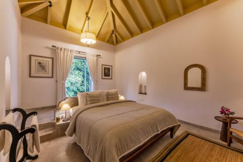a bedroom with a large bed and a window at Villa Lluvia 5bhk-Huge Pvt Pool-Caretaker-Bathtub-Big Garden-Genset Backup- Siolim in Oxel