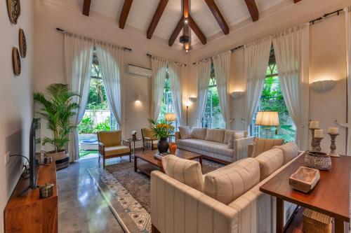 a living room with white furniture and large windows at Villa Lluvia 5bhk-Huge Pvt Pool-Caretaker-Bathtub-Big Garden-Genset Backup- Siolim in Oxel
