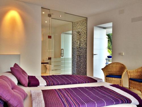 een slaapkamer met een bed met paarse lakens en een spiegel bij Castillo de ensueño in La Herradura