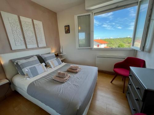 une chambre avec un lit avec deux serviettes dessus dans l'établissement Le Duna, à Soorts-Hossegor